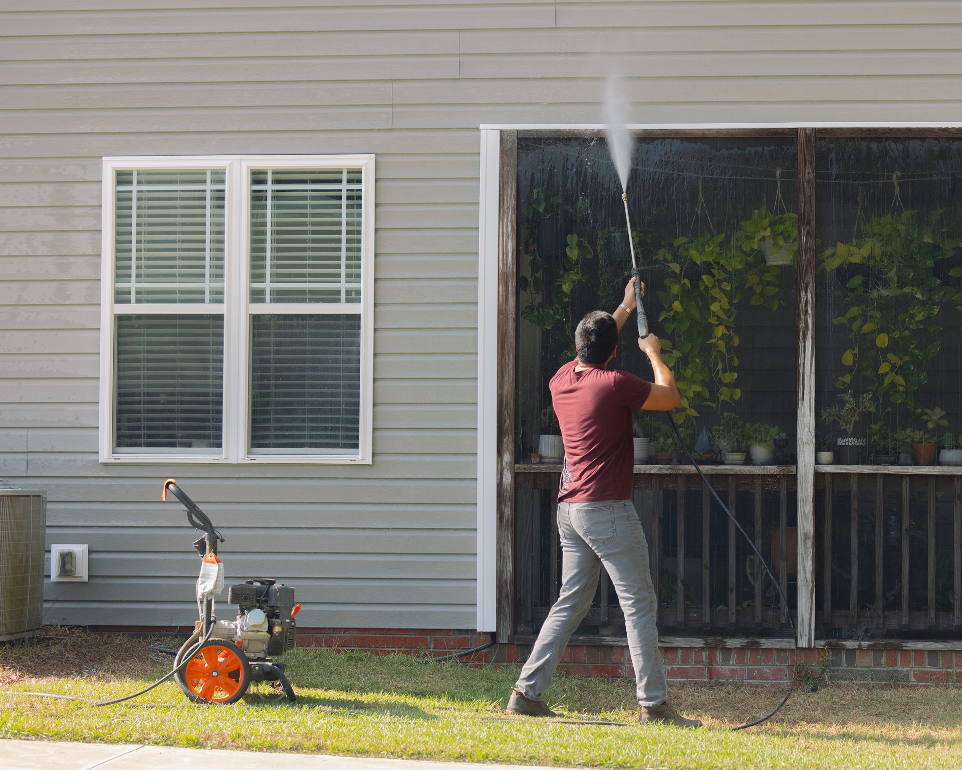 Man Pressure Washing Vinyl Siding - House